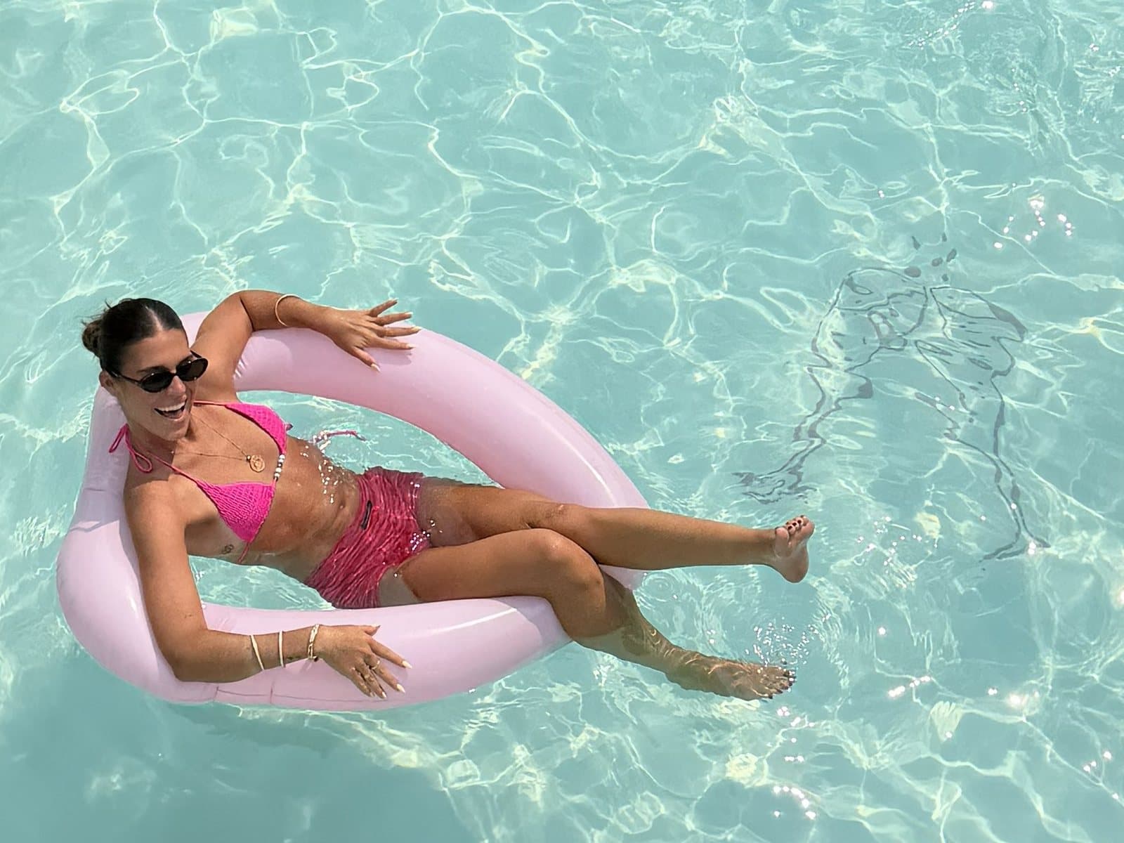 Guest relaxing on a pool float at Pink Champagne